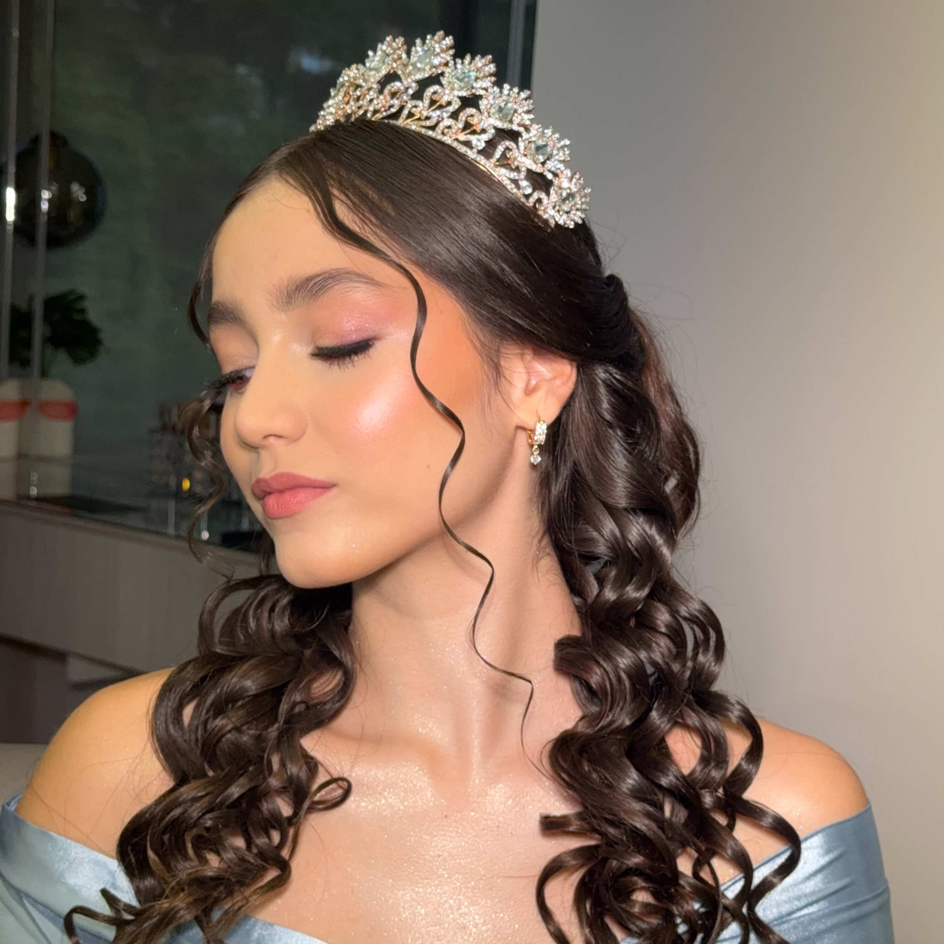 Quinceañera con tiara y rizos definidos